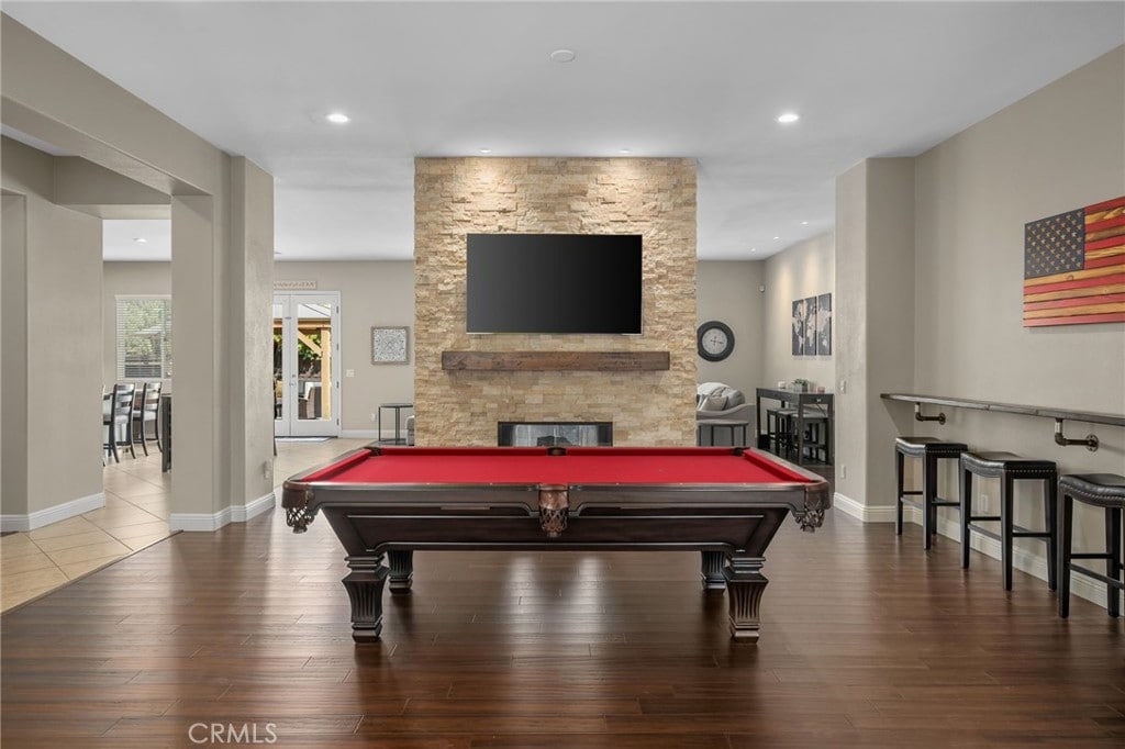 playroom featuring a stone fireplace, dark wood-type flooring, and billiards