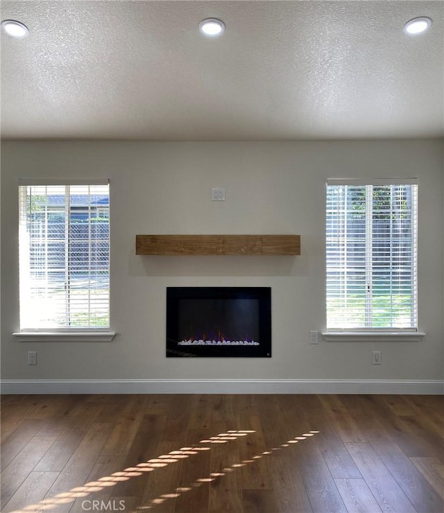 unfurnished living room with dark hardwood / wood-style floors and a textured ceiling