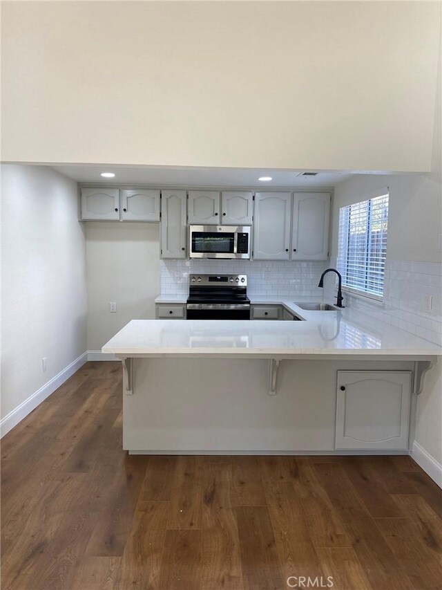 kitchen with sink, kitchen peninsula, and appliances with stainless steel finishes