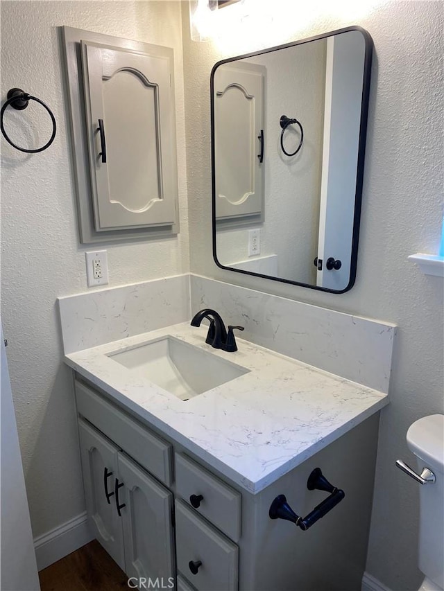 bathroom with vanity, hardwood / wood-style flooring, and toilet