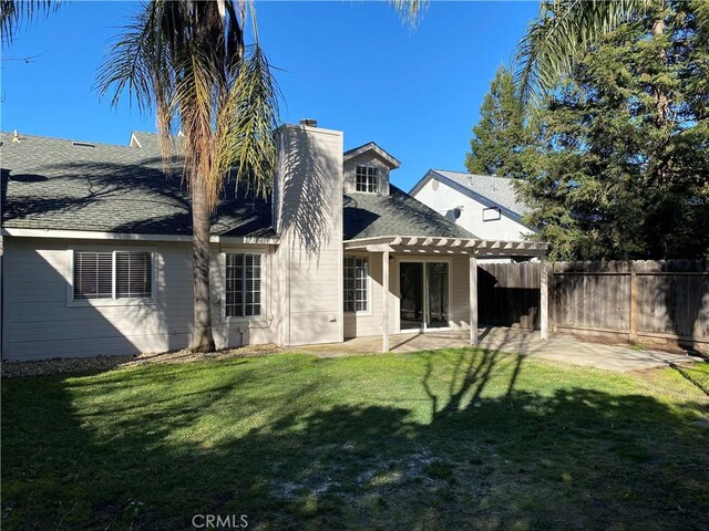 rear view of property with a patio, a yard, and a pergola