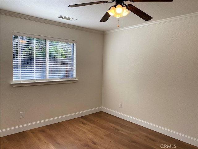 spare room featuring crown molding, wood-type flooring, and ceiling fan