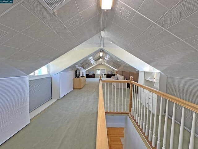 additional living space with vaulted ceiling and carpet