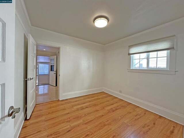 unfurnished room featuring crown molding and light hardwood / wood-style floors