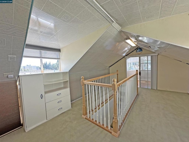 additional living space with vaulted ceiling and light colored carpet