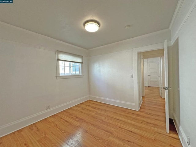 empty room featuring ornamental molding and light hardwood / wood-style floors