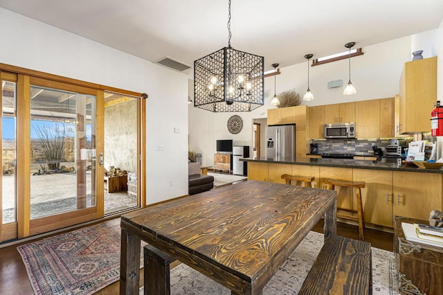 dining area featuring a towering ceiling, dark hardwood / wood-style flooring, and a chandelier