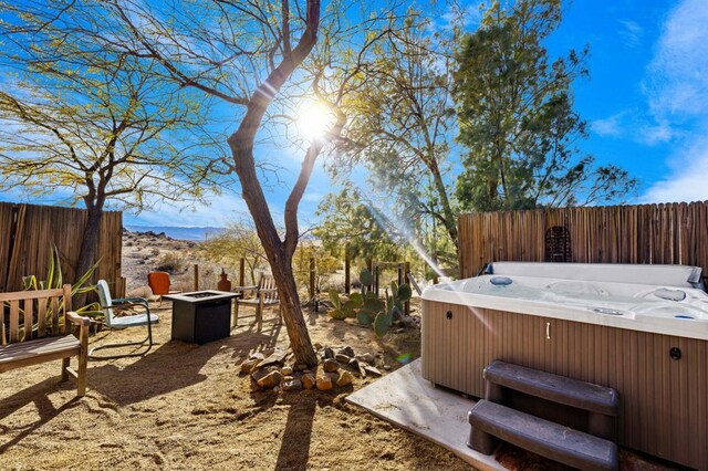 view of yard featuring a fire pit and a hot tub