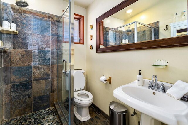 bathroom featuring walk in shower, sink, and toilet