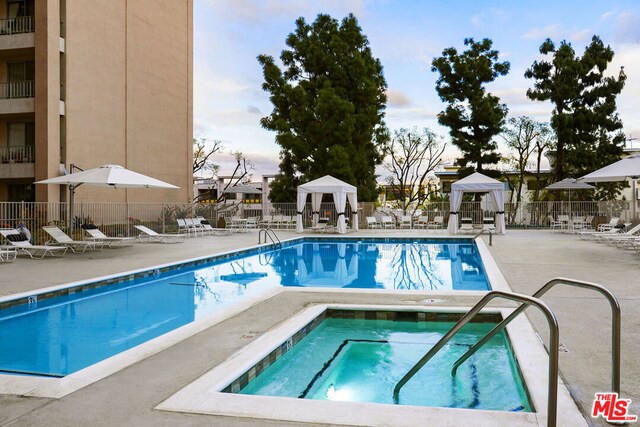 view of swimming pool with a gazebo, a patio, and a community hot tub