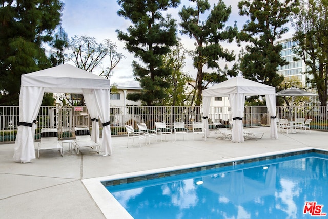 view of swimming pool featuring a gazebo and a patio area