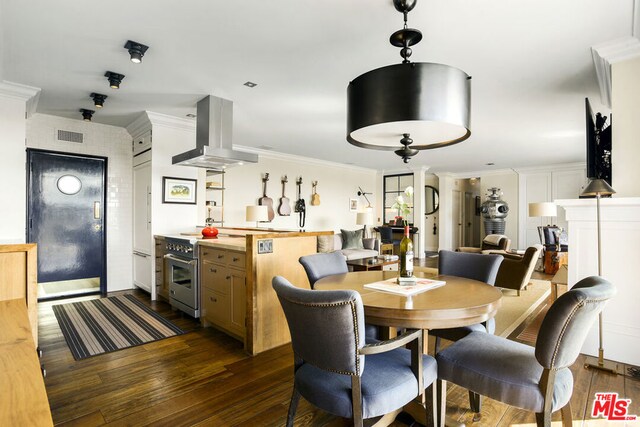 dining area featuring decorative columns, crown molding, and dark wood-type flooring