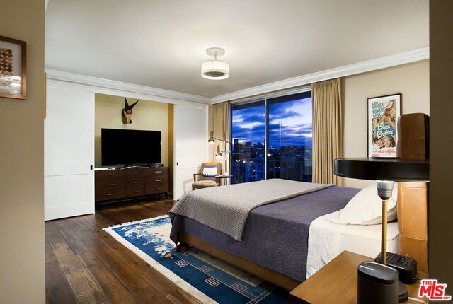 bedroom featuring crown molding and dark hardwood / wood-style flooring