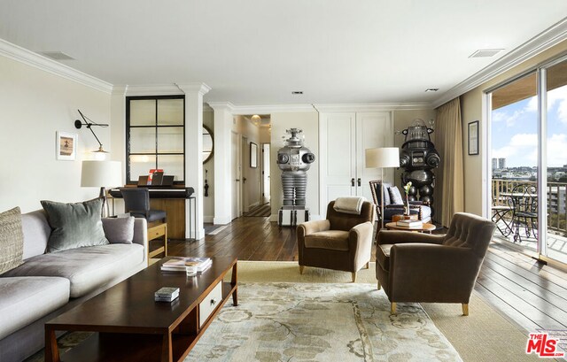 living room with hardwood / wood-style floors, ornamental molding, and decorative columns