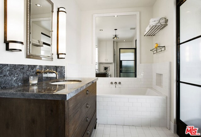 bathroom with tiled tub and vanity