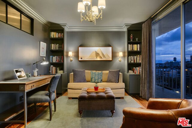 sitting room with hardwood / wood-style flooring, ornamental molding, and a chandelier