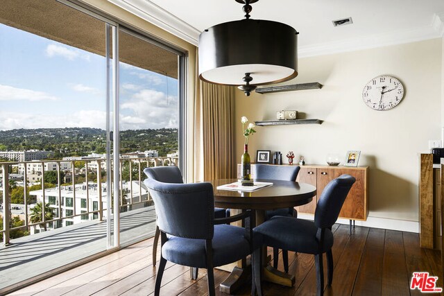 dining area with ornamental molding and dark hardwood / wood-style flooring