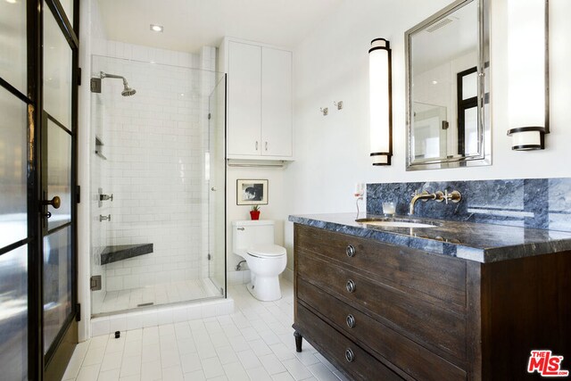 bathroom with vanity, a shower with door, and toilet