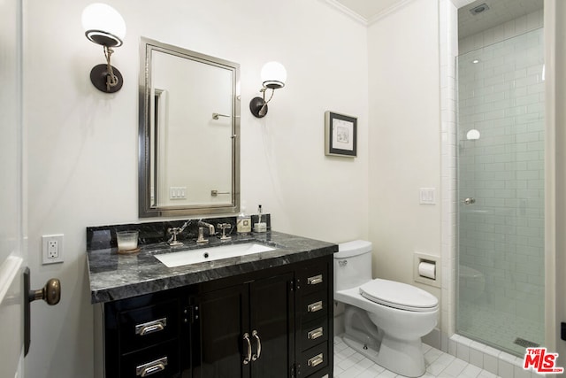 bathroom with tile patterned floors, toilet, a shower with shower door, vanity, and ornamental molding