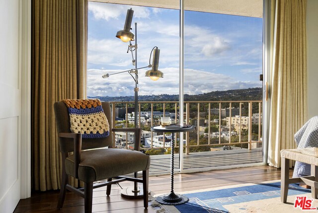 sitting room with hardwood / wood-style flooring and a wall of windows