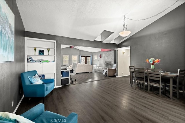 dining space featuring lofted ceiling, dark hardwood / wood-style floors, built in features, and a textured ceiling