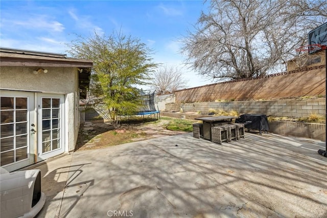 view of patio with a trampoline and french doors