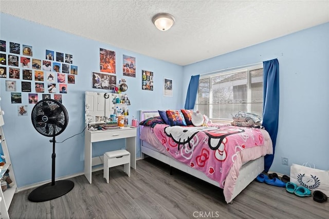 bedroom with hardwood / wood-style floors and a textured ceiling