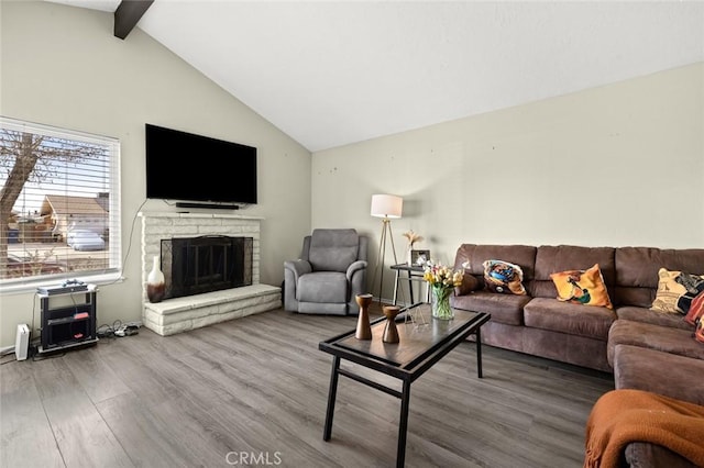 living room with beamed ceiling, wood-type flooring, high vaulted ceiling, and a fireplace