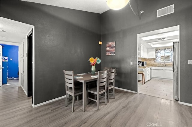 dining room with sink and light hardwood / wood-style floors