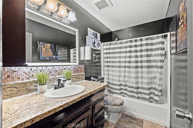 full bathroom featuring vanity, decorative backsplash, toilet, and shower / bath combo with shower curtain