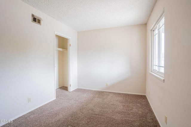 unfurnished bedroom with light carpet and a textured ceiling