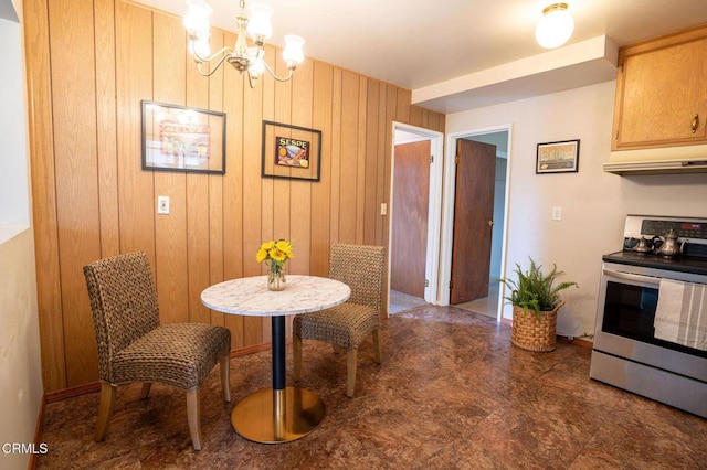 dining space with wooden walls and a notable chandelier