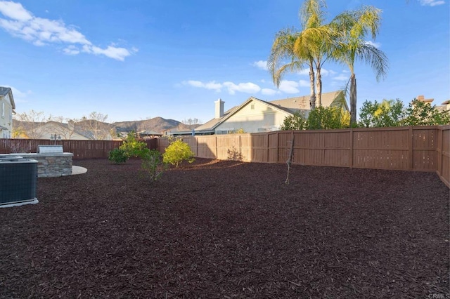 view of yard with central AC and a mountain view