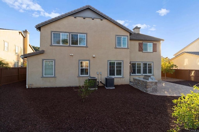 rear view of property featuring central AC and a patio area