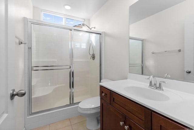 bathroom with vanity, toilet, tile patterned flooring, and a shower with door