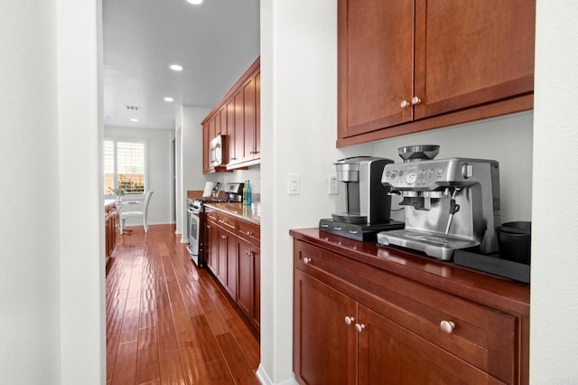 bar featuring stainless steel appliances and wood-type flooring