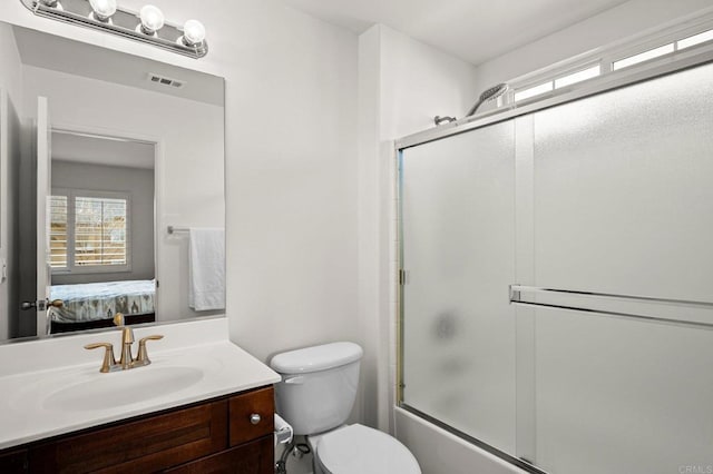 full bathroom with vanity, combined bath / shower with glass door, and toilet