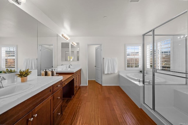 bathroom featuring independent shower and bath, wood-type flooring, and vanity