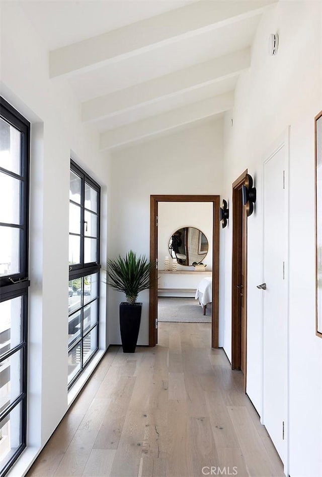 hall featuring lofted ceiling with beams and light hardwood / wood-style flooring