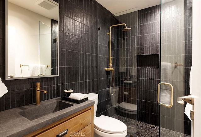 bathroom with tile walls, decorative backsplash, vanity, walk in shower, and toilet