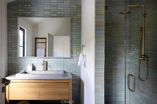 bathroom with vanity, tasteful backsplash, tile walls, and walk in shower