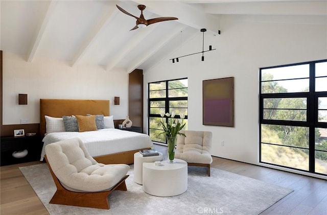 bedroom featuring hardwood / wood-style flooring, high vaulted ceiling, and beam ceiling