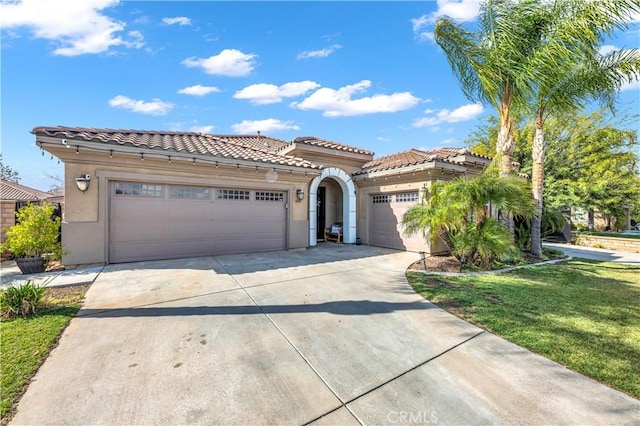 mediterranean / spanish home with a garage and a front yard