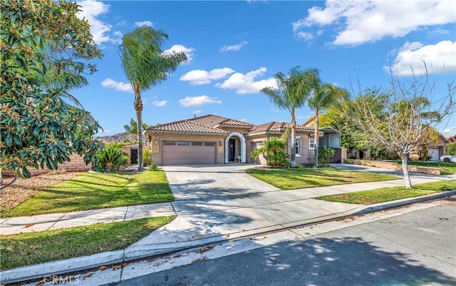 mediterranean / spanish home featuring a garage and a front lawn