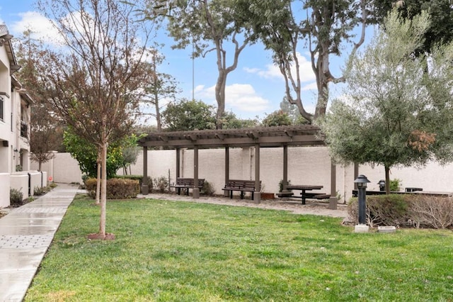 view of home's community with a yard and a pergola