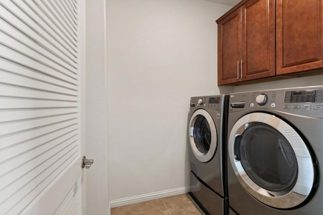 washroom with cabinets, light tile patterned floors, and washer and dryer