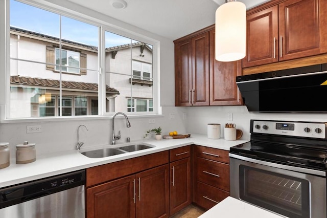 kitchen with sink, decorative light fixtures, ventilation hood, and stainless steel appliances