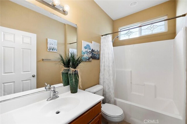 full bathroom with shower / tub combo with curtain, vanity, and toilet