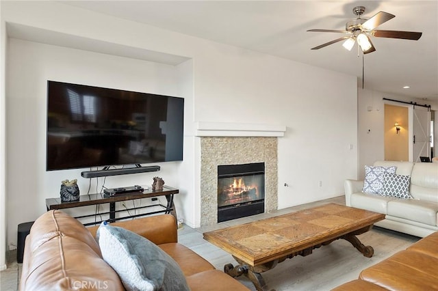 living room with a barn door and ceiling fan