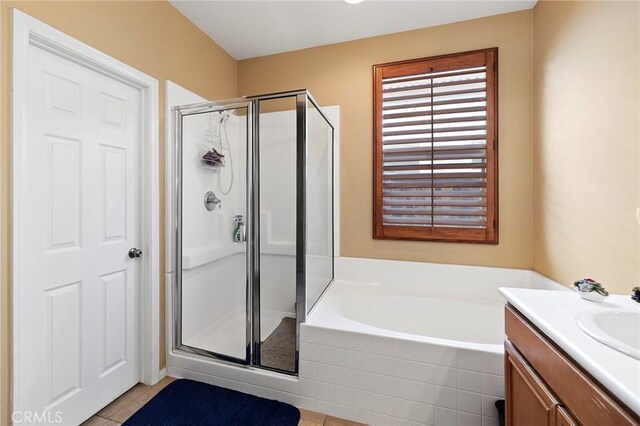 bathroom featuring vanity, plus walk in shower, and tile patterned flooring